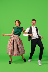 Image showing Old-school fashioned young woman dancing isolated on green background