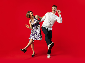 Image showing Old-school fashioned young couple dancing isolated on red background