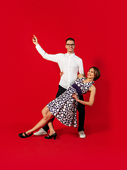 Image showing Old-school fashioned young couple dancing isolated on red background