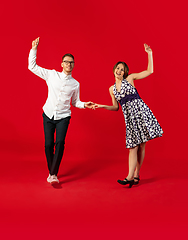 Image showing Old-school fashioned young couple dancing isolated on red background