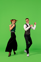 Image showing Old-school fashioned young woman dancing isolated on green background