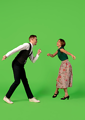 Image showing Old-school fashioned young woman dancing isolated on green background