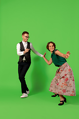 Image showing Old-school fashioned young woman dancing isolated on green background