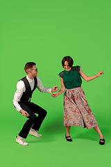 Image showing Old-school fashioned young woman dancing isolated on green background