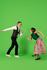 Image showing Old-school fashioned young woman dancing isolated on green background