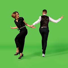 Image showing Old-school fashioned young woman dancing isolated on green background