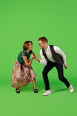 Image showing Old-school fashioned young woman dancing isolated on green background