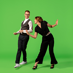 Image showing Old-school fashioned young woman dancing isolated on green background