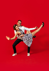 Image showing Old-school fashioned young couple dancing isolated on red background