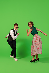 Image showing Old-school fashioned young woman dancing isolated on green background