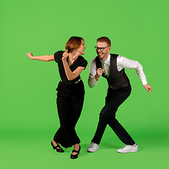 Image showing Old-school fashioned young woman dancing isolated on green background