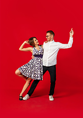 Image showing Old-school fashioned young couple dancing isolated on red background