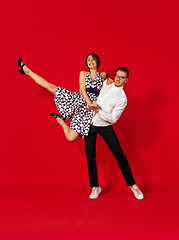 Image showing Old-school fashioned young couple dancing isolated on red background