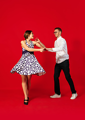 Image showing Old-school fashioned young couple dancing isolated on red background