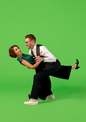 Image showing Old-school fashioned young woman dancing isolated on green background