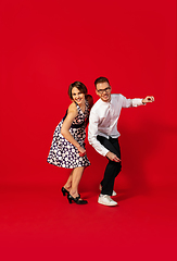 Image showing Old-school fashioned young couple dancing isolated on red background