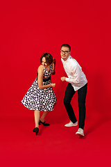 Image showing Old-school fashioned young couple dancing isolated on red background