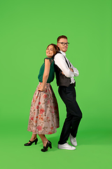 Image showing Old-school fashioned young woman dancing isolated on green background