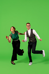 Image showing Old-school fashioned young woman dancing isolated on green background