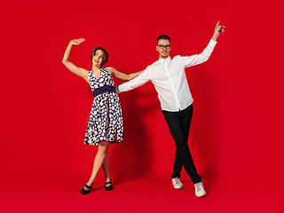 Image showing Old-school fashioned young couple dancing isolated on red background