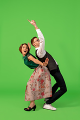 Image showing Old-school fashioned young woman dancing isolated on green background