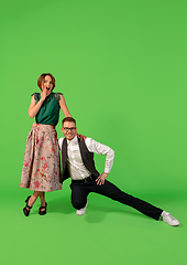 Image showing Old-school fashioned young woman dancing isolated on green background