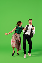 Image showing Old-school fashioned young woman dancing isolated on green background