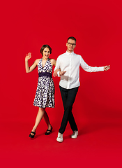 Image showing Old-school fashioned young couple dancing isolated on red background