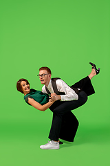 Image showing Old-school fashioned young woman dancing isolated on green background