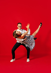 Image showing Old-school fashioned young couple dancing isolated on red background