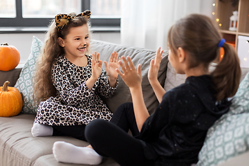 Image showing girls in halloween costumes playing game at home