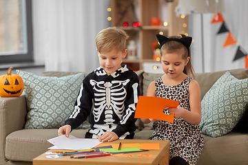 Image showing kids in halloween costumes doing crafts at home