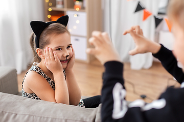 Image showing kids in halloween costumes playing at home