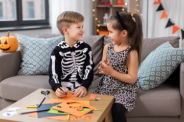 Image showing kids in halloween costumes doing crafts at home