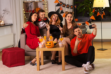 Image showing happy friends in halloween costumes taking selfie