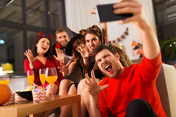 Image showing happy friends in halloween costumes taking selfie