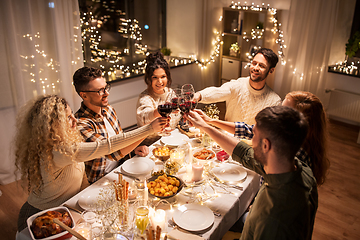 Image showing happy friends drinking red wine at christmas party