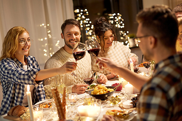 Image showing happy friends drinking red wine at christmas party