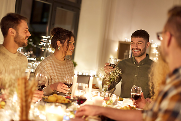 Image showing happy friends drinking red wine at christmas party