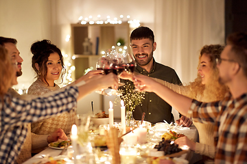 Image showing happy friends drinking red wine at christmas party