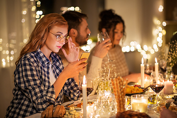 Image showing woman with smartphone at dinner party with friends