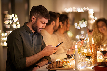 Image showing man with smartphone at dinner party with friends