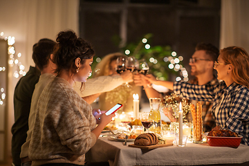 Image showing woman with smartphone at dinner party with friends