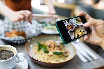 Image showing Friends taking photo on dish in restaurant