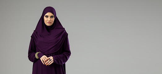 Image showing Beautiful arab woman posing in stylish hijab isolated on studio background. Fashion concept