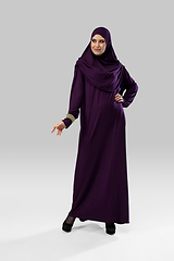 Image showing Beautiful arab woman posing in stylish hijab isolated on studio background. Fashion concept