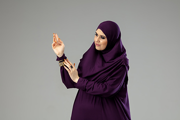 Image showing Beautiful arab woman posing in stylish hijab isolated on studio background. Fashion concept