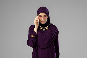 Image showing Beautiful arab woman posing in stylish hijab isolated on studio background. Fashion concept