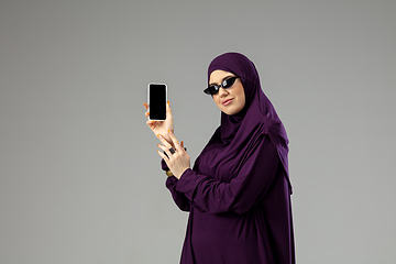 Image showing Beautiful arab woman posing in stylish hijab isolated on studio background. Fashion concept