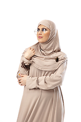 Image showing Beautiful arab woman posing in stylish hijab isolated on studio background. Fashion concept